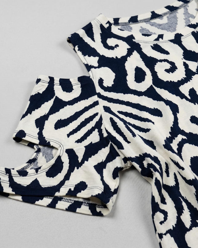 Детайл отблизо на бежова лятна туника големи размери, фокусиращ се върху дизайна на ръкава с отворено рамо и контрастния абстрактен принт.