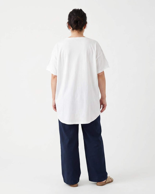 Изглед отзад на бяла лятна памучна туника големи размери със свободна кройка и заоблен подгъв, заснета в цял ръст на бял фон.