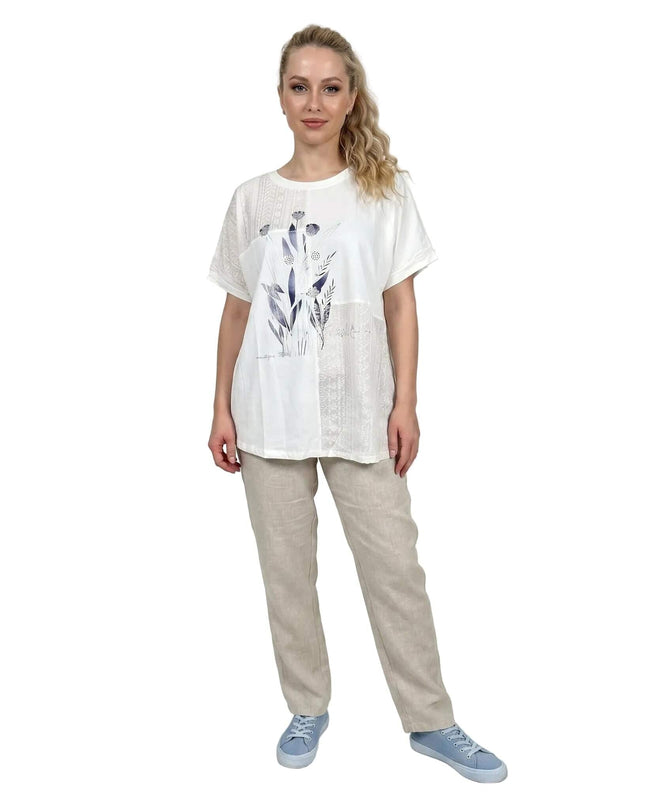 Бяла лятна туника големи размери с флорална апликация, облечена от модел в цял ръст на бял фон.