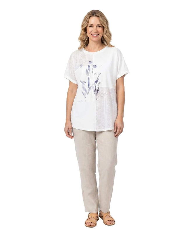 Бяла лятна туника големи размери с флорална апликация и къс ръкав. Кадър в цял ръст, показващ модела отпред.