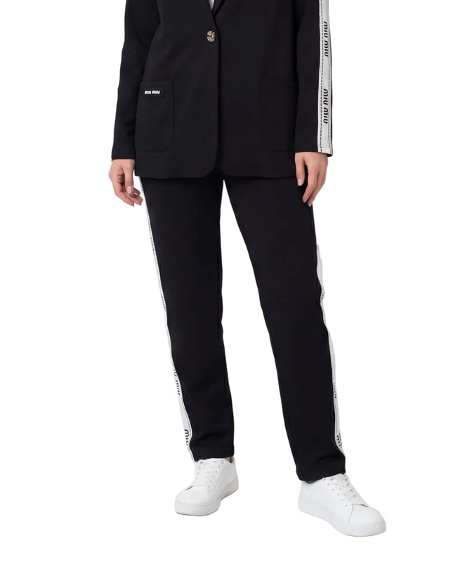 Черен ежедневен дамски комплект сако и панталон големи размери, детайлен поглед върху панталона с бял страничен кант и бели кецове.