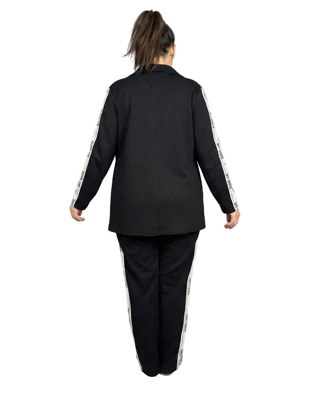 Черен дамски комплект от две части сако и панталон големи размери, изглед отзад с бели декоративни ленти по ръкавите и крачолите.