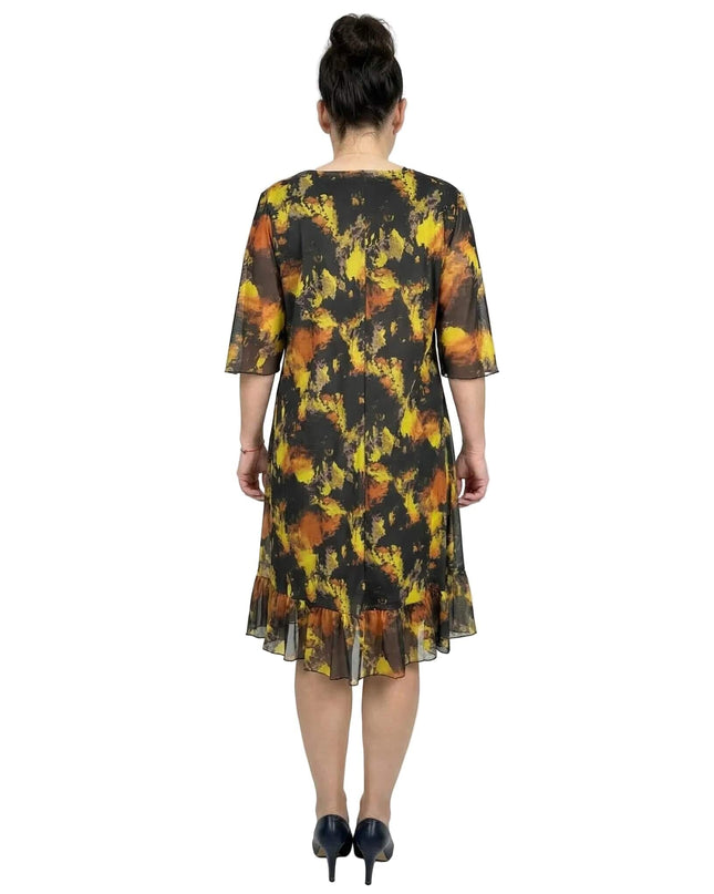 Черна официална шифонена рокля големи размери с жълт абстрактен принт и нежен волан. Изглед отзад на бял фон.