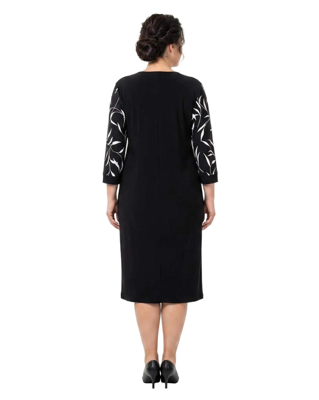 Черна официална рокля големи размери с бели флорални мотиви по ръкавите, изглед отзад в цял ръст на бял фон.