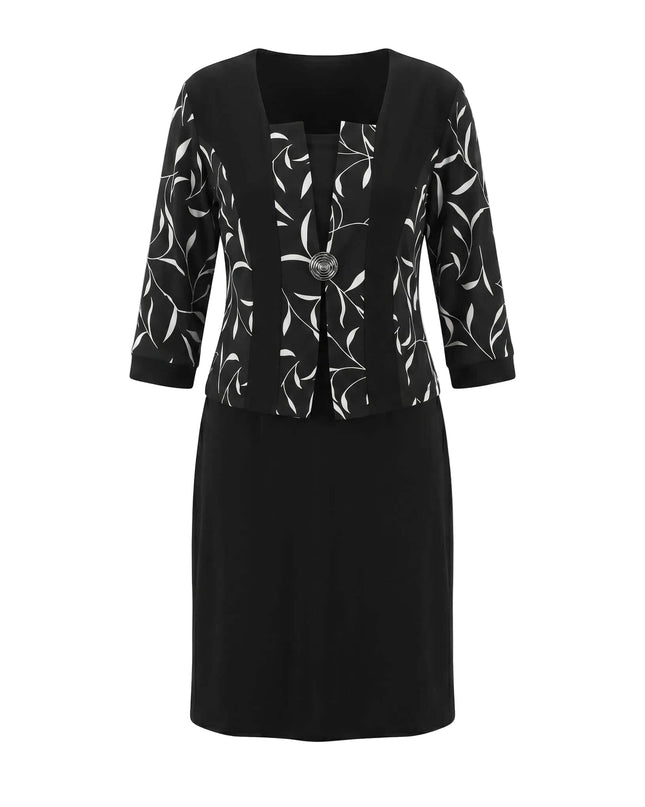 Черна официална рокля големи размери с бял листен мотив, 3/4 ръкави и брошка, заснета отпред на бял фон.