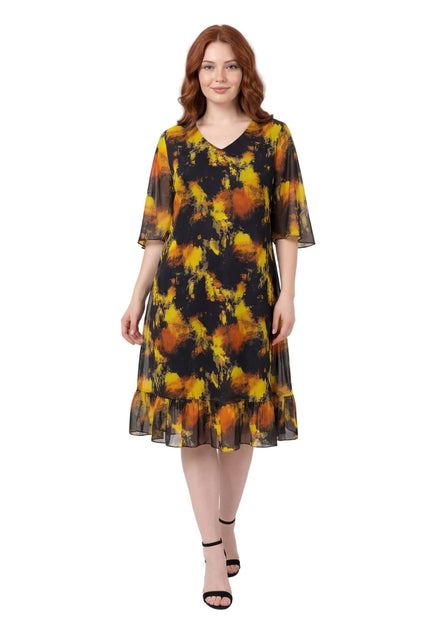 Черна официална шифонена рокля големи размери с абстрактен жълт принт и V-образно деколте, заснета в цял ръст на бял фон.
