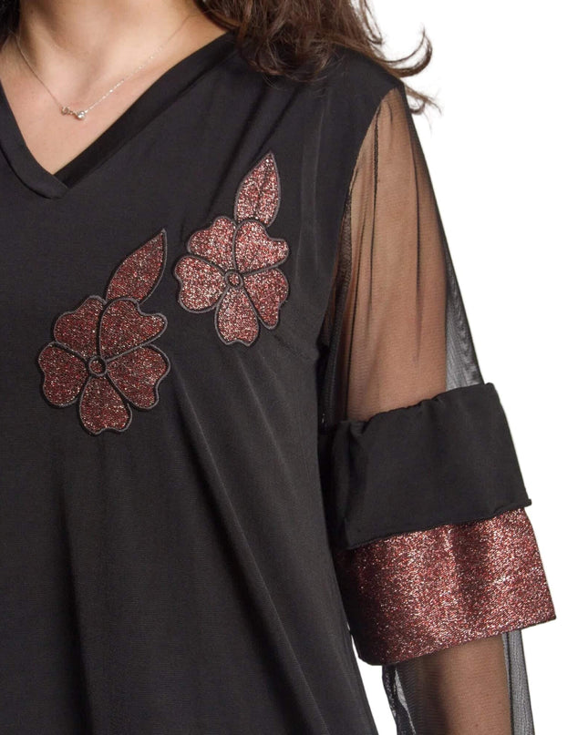 Детайлен кадър на черна официална туника, показващ блестящи цветя в бордо и тюлен ръкав с широк маншет с металически ефект.