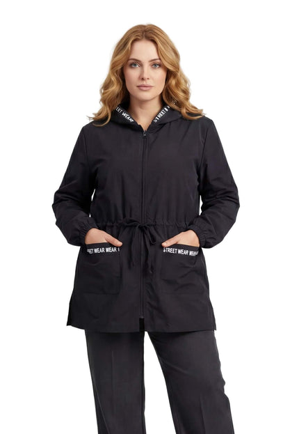 Черна разкроена макси ветровка с качулка и джобове с декоративни бели надписи, заснета отпред.