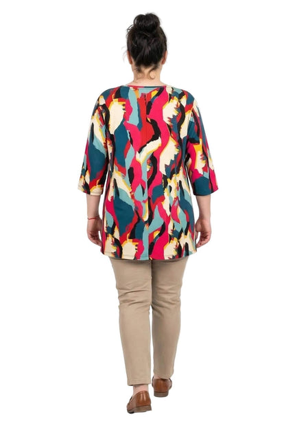 Дълга лятна макси туника с шарен абстрактен принт, представена отзад в цял ръст на бял фон в съчетание с бежов панталон.