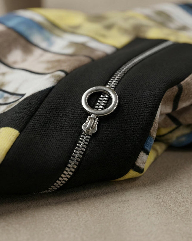 Детайл отблизо на сребристия цип с кръгъл плъзгач и абстрактния цветен принт на удобна дълга макси туника, показващ меката материя.