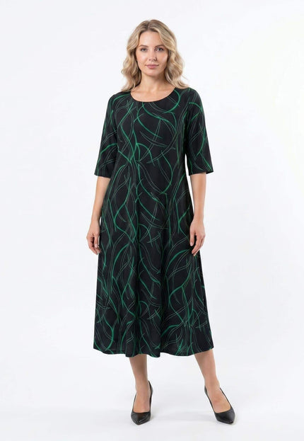 Дълга официална макси рокля в черно със зелен абстрактен принт и къси ръкави, заснета в цял ръст отпред на бял фон.