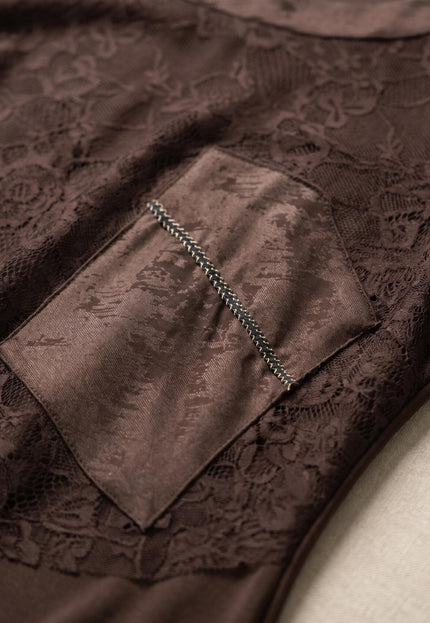 Детайл отблизо на официална макси рокля в кафяво, показващ ефектен декоративен джоб и елегантна флорална дантела.
