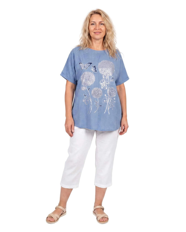 Дамска лятна синя туника големи размери с флорална апликация, къси ръкави и заоблен подгъв, заснета в цял ръст на бял фон.