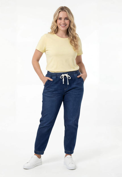 Дамски еластични дънки в син цвят с ластик и бели връзки на талията, както и ластик на глезените. Кадър в цял ръст.