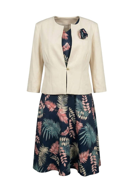 Елегантен дамски костюм големи размери, съчетаващ тъмносиня рокля с цветни мотиви и стилно бежово сако с брошка, заснет на бял фон.