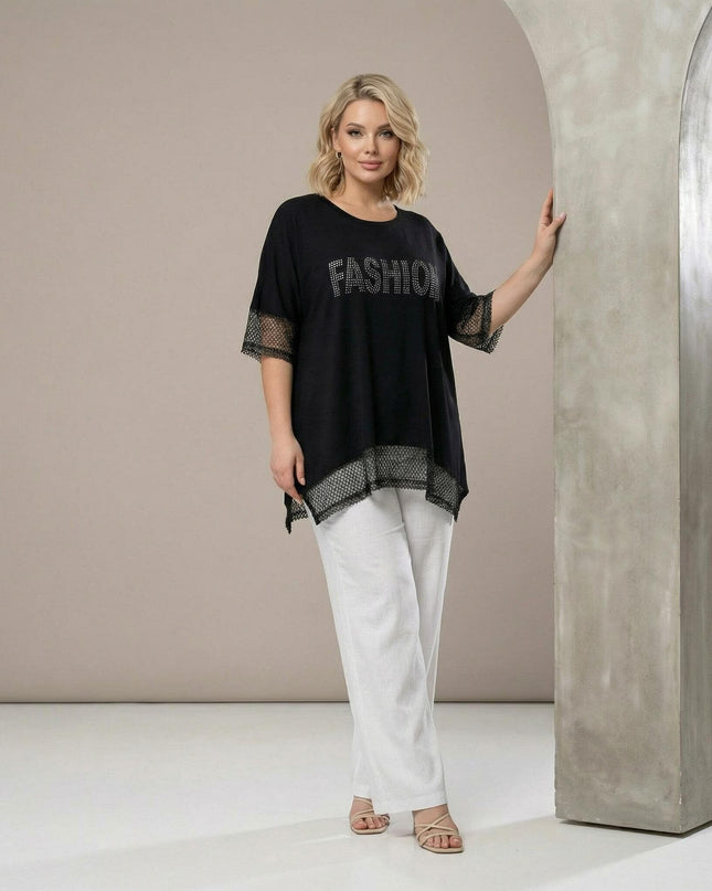 Елегантна черна туника с асиметричен подгъв, мрежести елементи и надпис FASHION от камъчета, заснета в цял ръст.