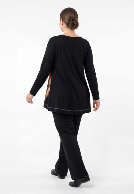 Елегантна есенна туника в черно, заснета отзад в цял ръст. Вижда се изчистеният гръб с централен шев, дългите ръкави и свободната кройка на модела.