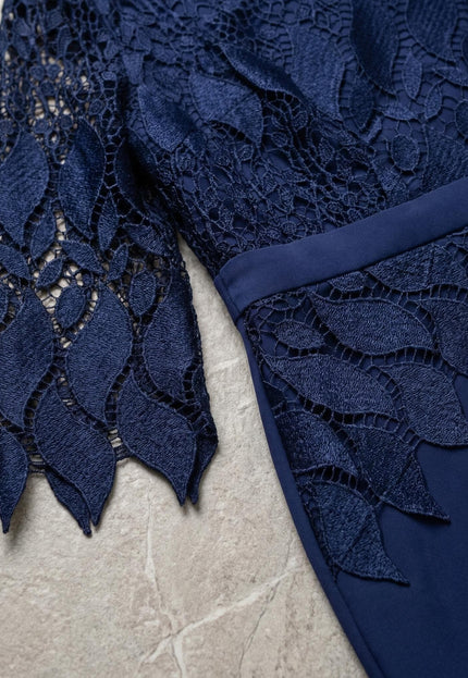 Детайл отблизо на изящната дантела с флорални мотиви по ръкава и талията на тази елегантна тъмносиня макси рокля.
