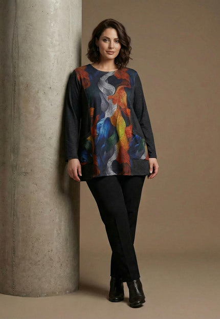 Елегантна туника с абстрактен принт Есенни листа и едноцветни страни, представена в цял ръст върху модел с черен панталон.