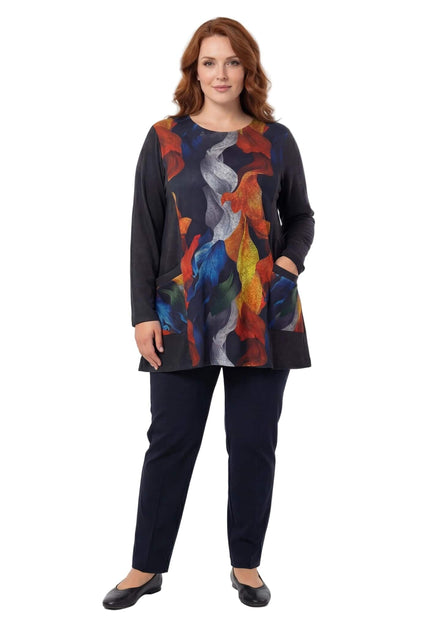 Елегантна дамска туника в цял ръст с цветен абстрактен принт на есенни листа и черни странични части. Моделът позира отпред на бял фон с черен панталон.
