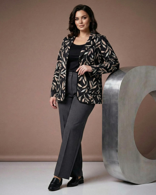 Елегантно черно макси сако с абстрактен десен на листа, представено в цял ръст върху модел до декоративен метален елемент.