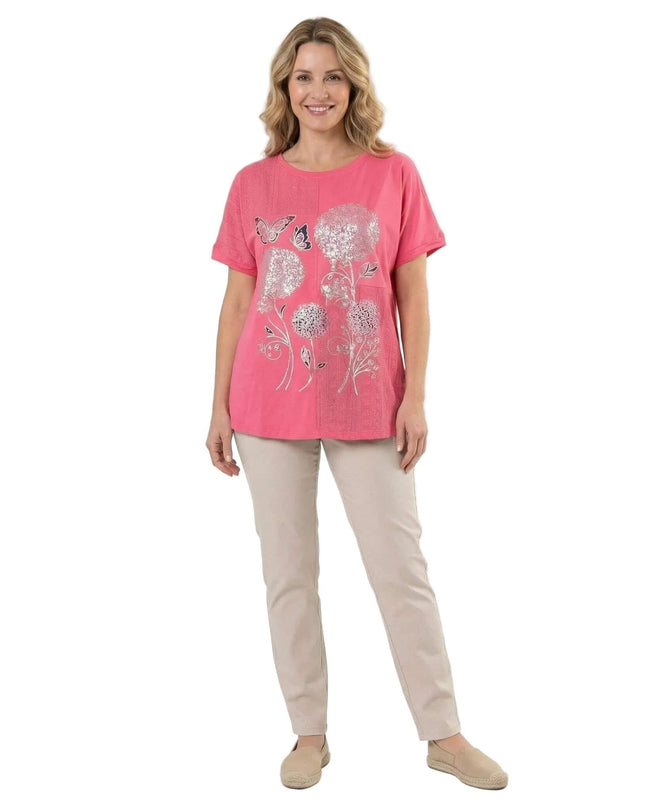 Лятна памучна туника в цвят корал с красива апликация на цветя и къс ръкав, представена в цял ръст на бял фон.