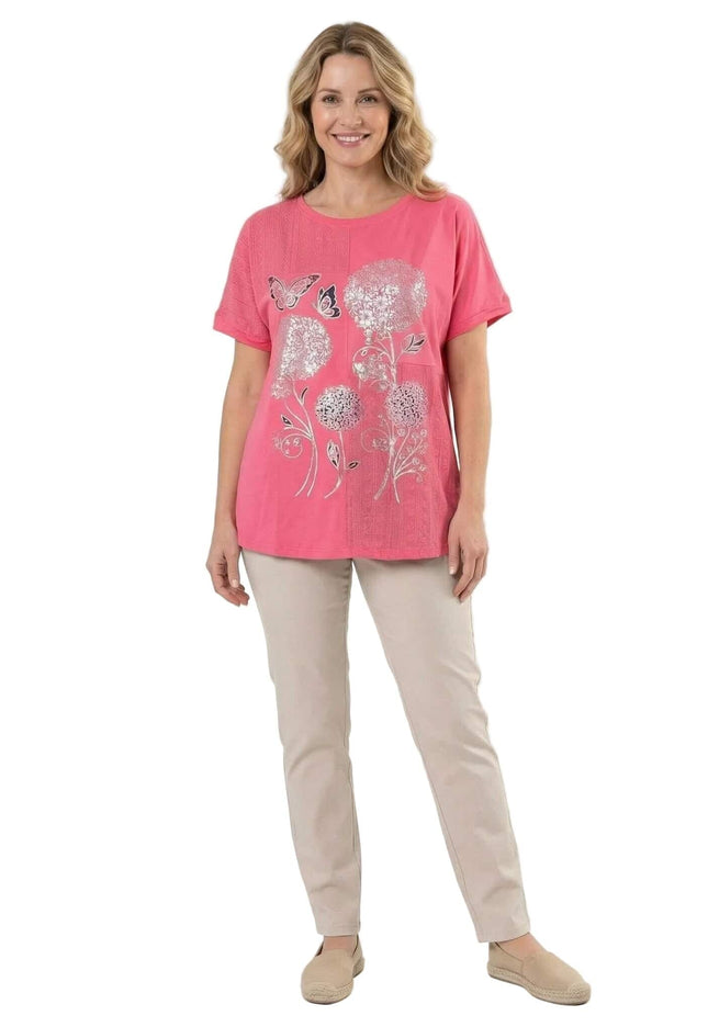 Лятна памучна туника в цвят корал с красива апликация на цветя и къс ръкав, представена в цял ръст на бял фон.