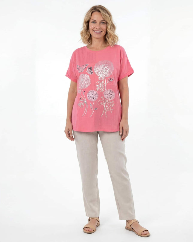 Лятна памучна туника в цвят корал с флорална апликация и къси ръкави, представена в цял ръст на бял фон.