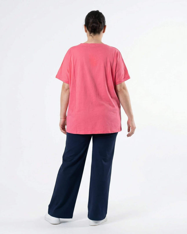 Дамска лятна памучна туника в цвят корал, изглед отзад. Моделът е с къс ръкав и свободна кройка, заснет в цял ръст на бял фон.