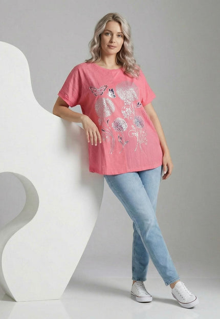 Лятна памучна туника в цвят корал със сребриста флорална апликация и пеперуди. Кадър в цял ръст на модел, съчетал дрехата със светли дънки.