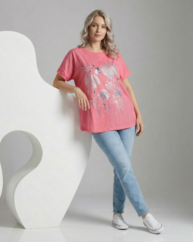 Лятна памучна туника в цвят корал със сребриста флорална апликация и пеперуди. Кадър в цял ръст на модел, съчетал дрехата със светли дънки.