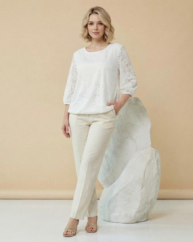 Официална бяла макси туника с релефен флорален десен и 7/8 ръкави, представена в цял ръст в комбинация с елегантен светъл панталон.