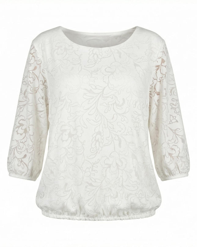 Официална бяла макси туника с нежен флорален десен и 7/8 ръкави. Представена отпред на бял фон, акцентираща върху облото деколте и ластика на подгъва.