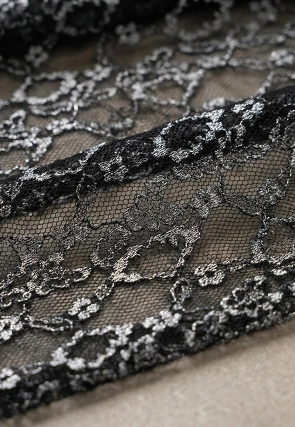 Детайл отблизо на фината флорална дантела с бляскави нишки, част от елегантната официална черна макси рокля.
