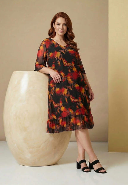 Официална черна макси рокля с шифон и огнен принт, представена в цял ръст. Моделът се отличава с ефирни ръкави и елегантен подгъв с волан.