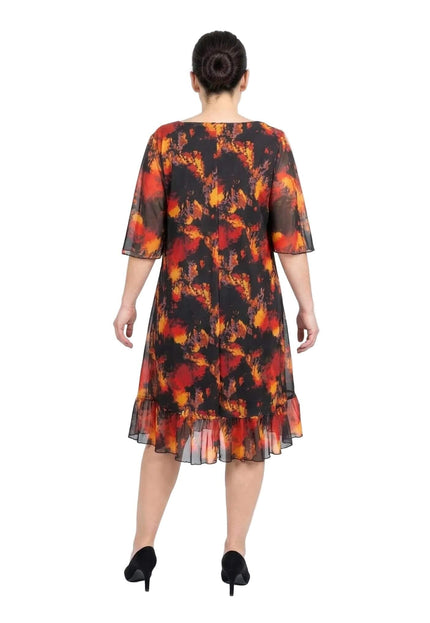 Официална черна макси рокля с шифон и огнен принт големи размери. Изглед отзад, разкриващ прозрачните ръкави и подгъва с волан.