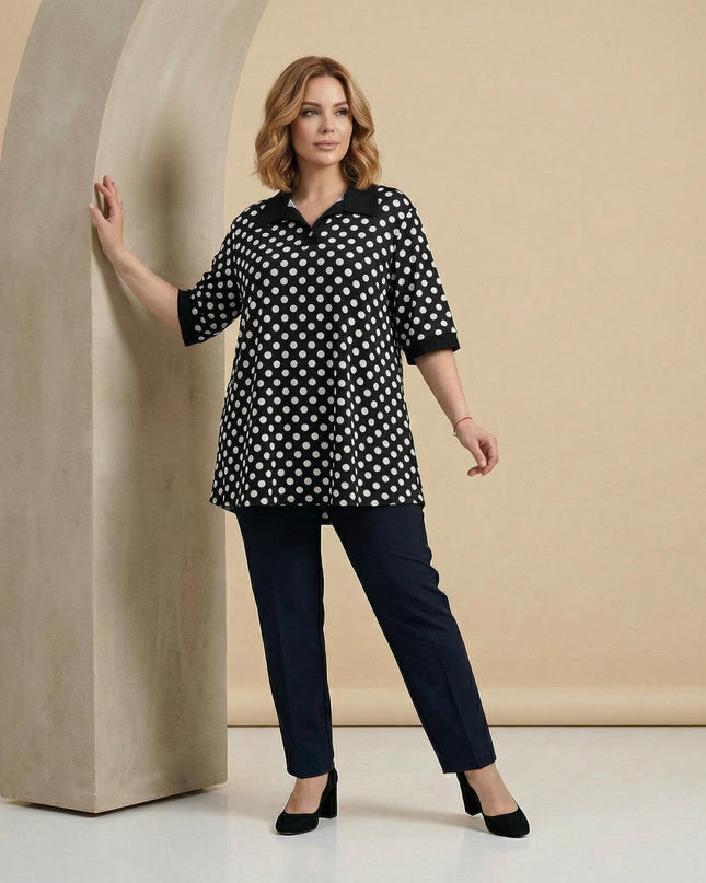 Елегантна визия в цял ръст с официална черна макси туника на бели точки, завършена с черна яка и къси ръкави с плътни маншети.