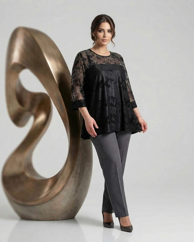 Официална черна туника големи размери с разкроен силует и ефектни ръкави с бродерия, заснета в цял ръст на светлосив фон.