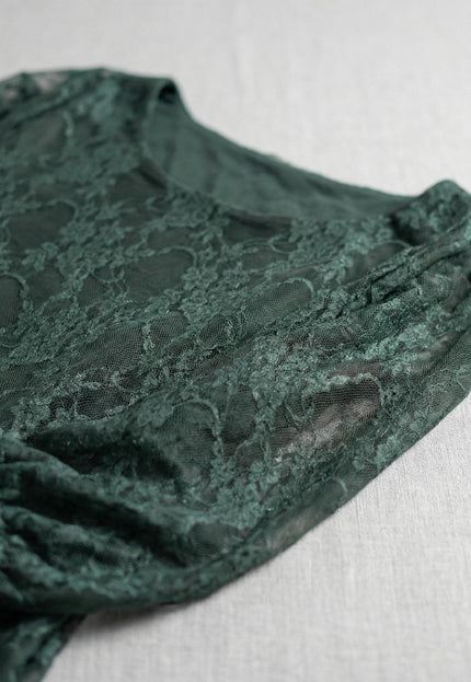 Официална дантелена туника в масленозелен цвят – близък план на флоралната материя, деколтето и ръкава, представена като плосък кадър върху светъл фон.