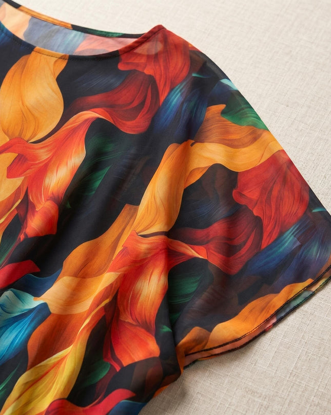 Детайл отблизо на официална лятна макси туника, показващ ефирната материя и красивия пъстър десен с абстрактни мотиви около деколтето.