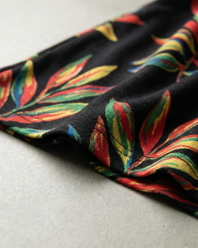 Детайл отблизо на официална макси туника, показващ качествената изработка на подгъва и наситения пъстър десен върху черна основа.