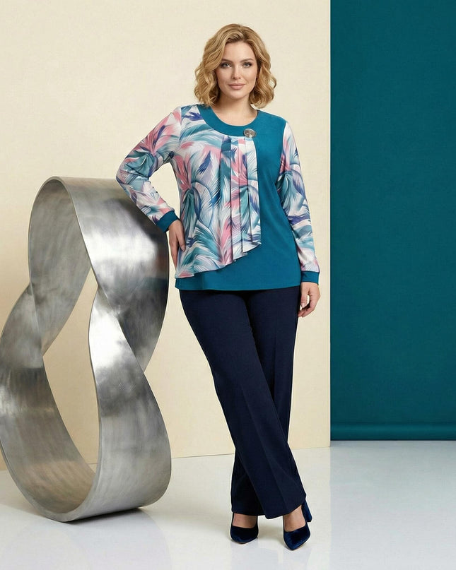 Официална макси туника в цвят петрол с асиметричен ефирен шифон на цветя и брошка, представена в цял ръст върху модел.