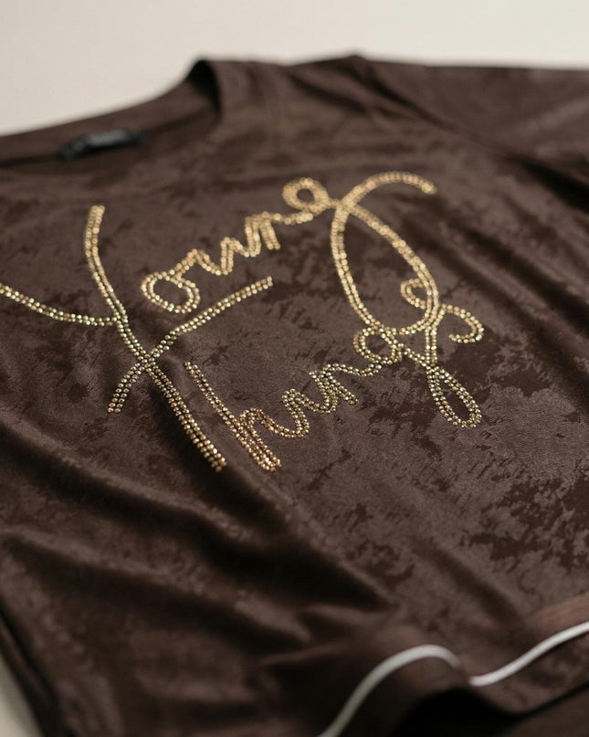 Детайл отблизо на кафява официална туника. Вижда се релефната материя, белият кант и красивият блестящ надпис от камъчета.