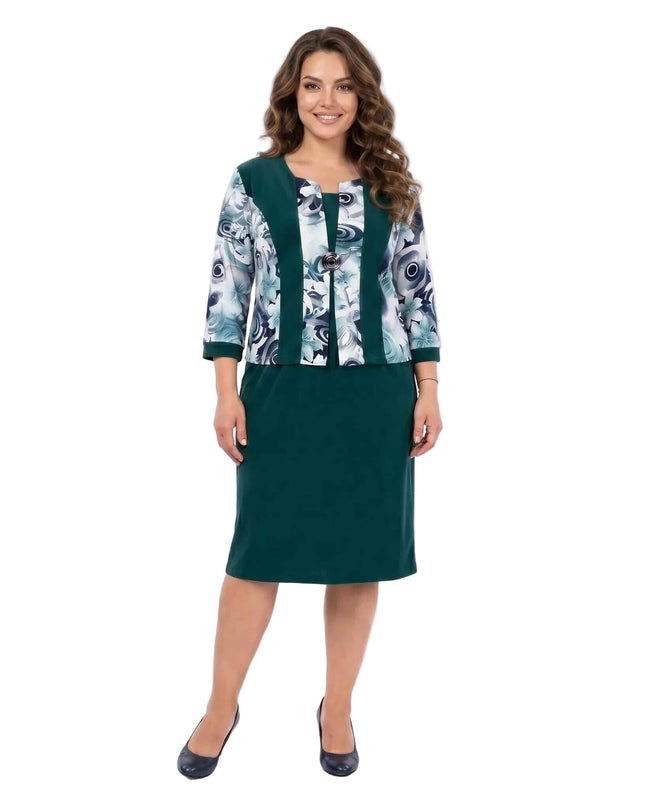 Официална масленозелена рокля за едри дами, с ефектен флорален десен и брошка, заснета в цял ръст.