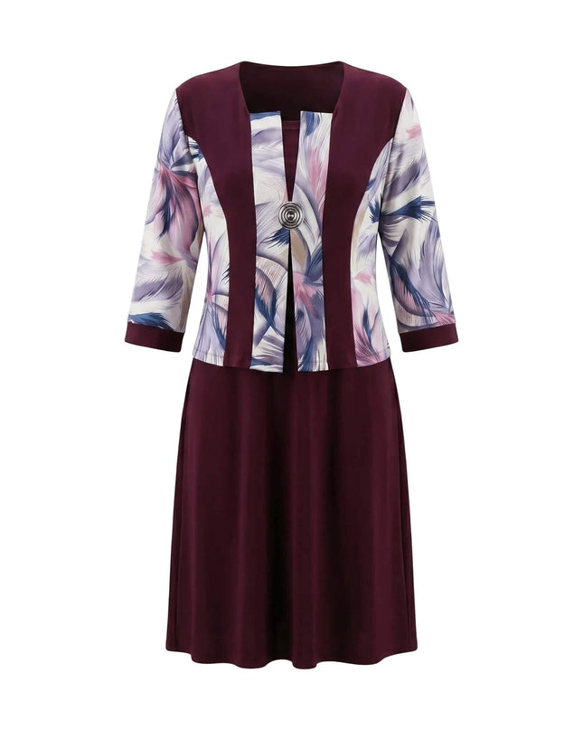 Официална права макси рокля в цвят бордо с абстрактен принт и декоративна брошка, заснета отпред на бял фон.