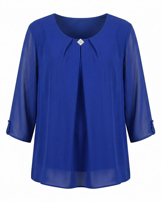Официална разкроена туника от шифон в кралскосин цвят с декоративна брошка на деколтето. Снимката показва преден изглед на дрехата с 7/8 ръкави върху бял фон.