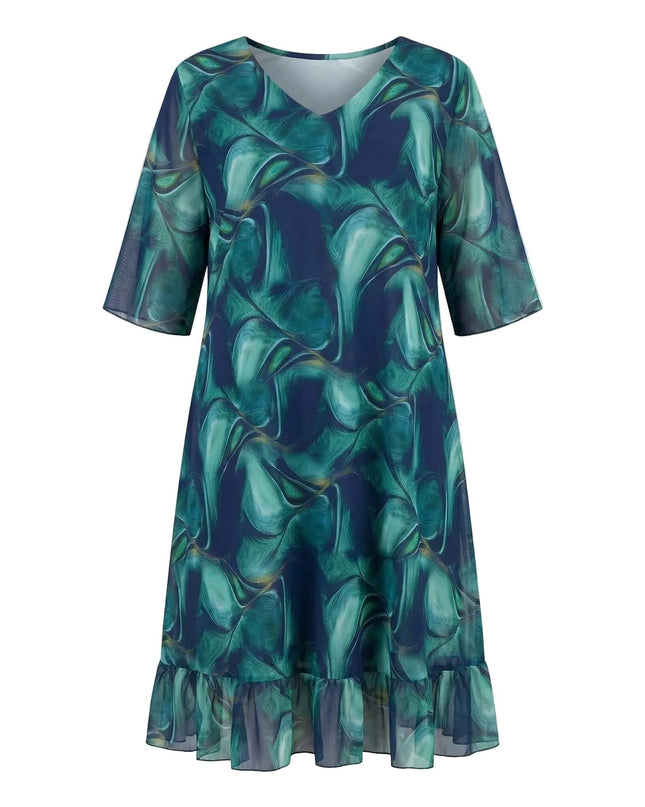 Официална шифонена рокля големи размери с абстрактен десен в синьо и зелено, V-образно деколте и подгъв с волан. Продуктов кадър на бял фон.