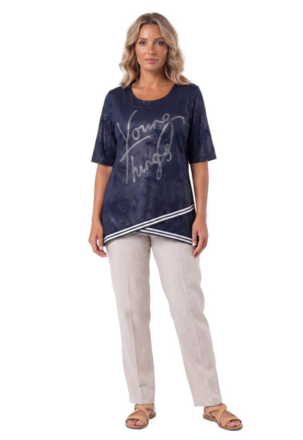 Тъмносиня туника големи размери с къс ръкав, блестящ надпис от камъчета и асиметричен раиран подгъв, представена в цял ръст.