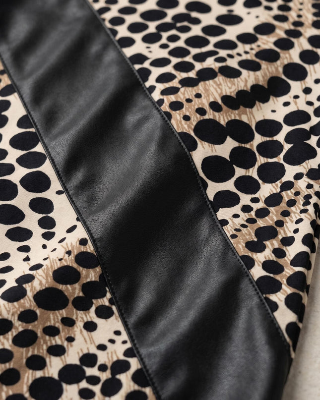 Детайл отблизо на официална туника големи размери, показващ диагонална платка от черна еко кожа, разположена върху леопардов принт на светъл фон.