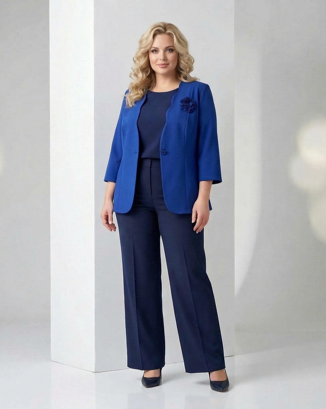 Официално дамско сако в кралскосин цвят с текстилна роза, съчетано с тъмносин панталон и топ, представено в цял ръст.